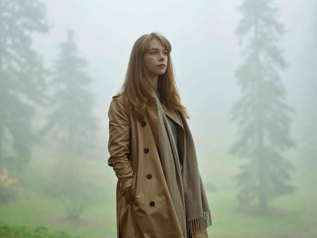 Woman standing in misty landscape, reflecting on grief and emotions