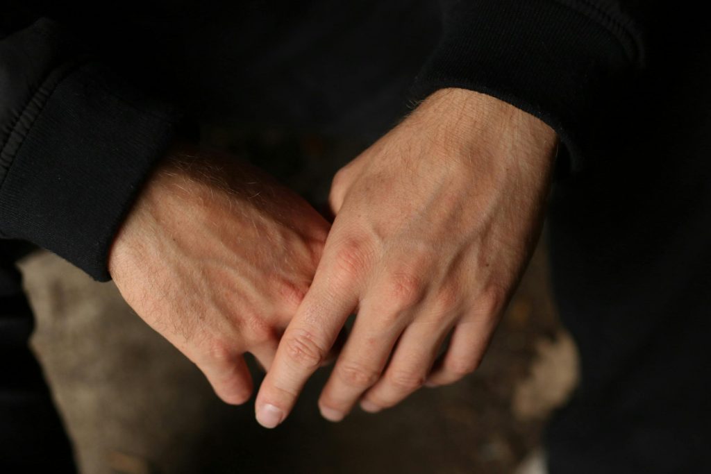 Hands resting together , expressing quiet grief and reflection
