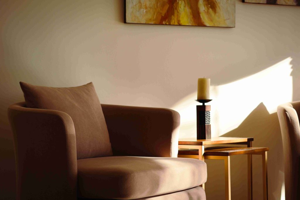 Comfortable armchair in a warmly lit room with soft cushions and natural sunlight